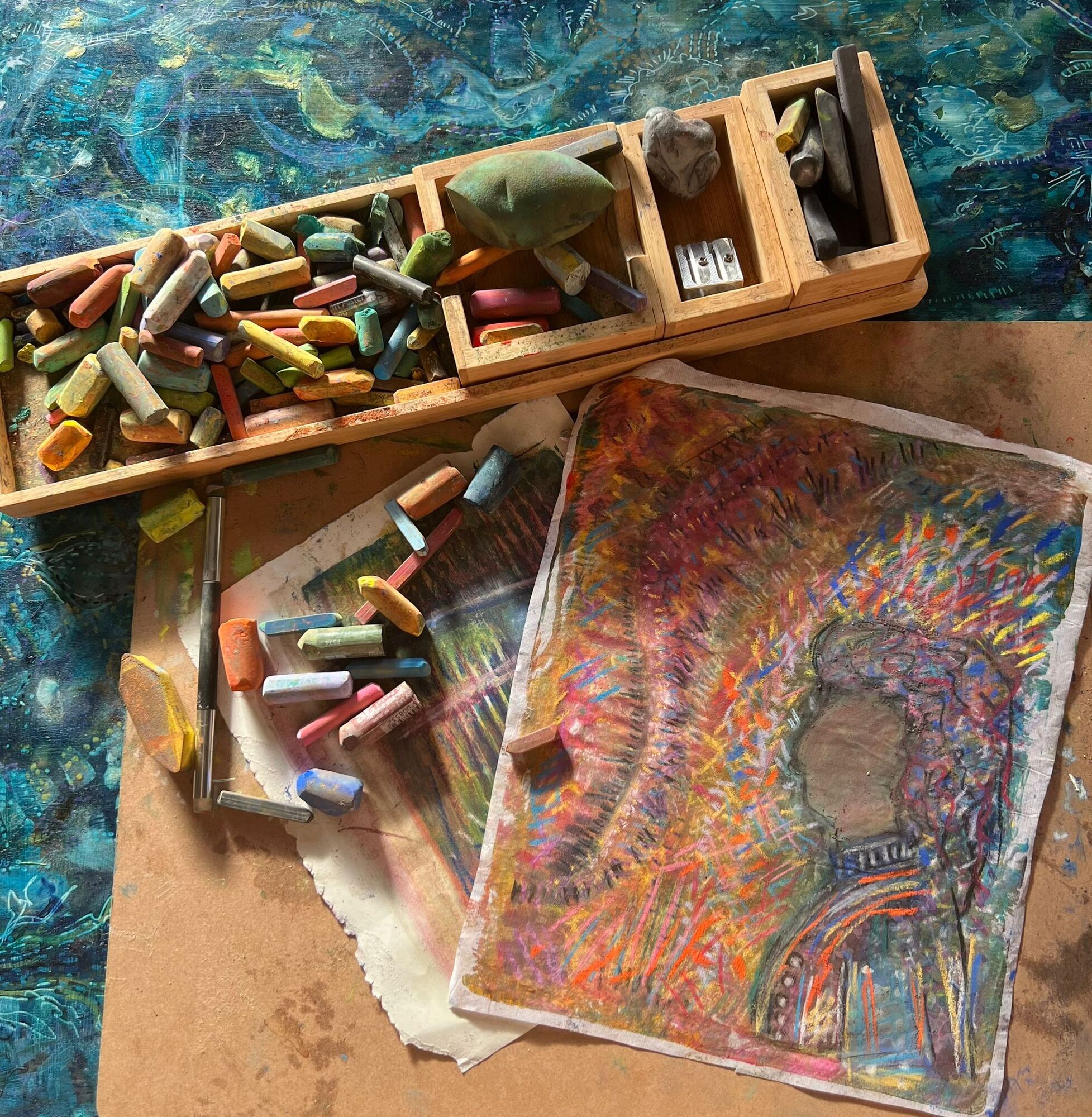 Two pieces of art on a table with drawing tools